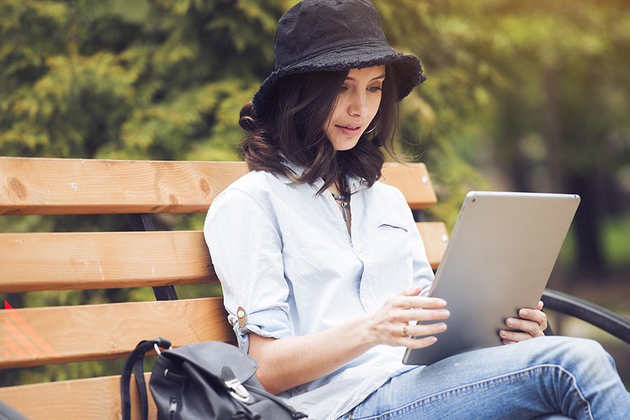 Client Center - Woman Using Her Tablet While in the Park